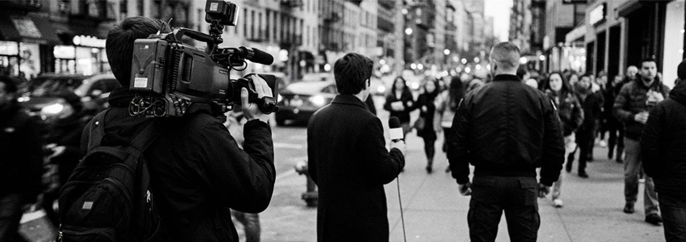 Security agent protecting a TV news crew filming a reporter on a city street